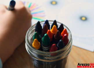 bambino che colora con i pastelli in asilo