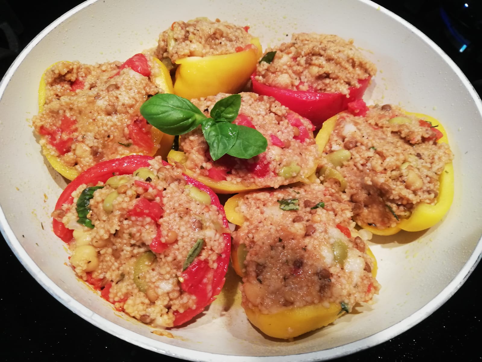 Pomodori e peperoni ripieni di cous cous e legumi al tegame