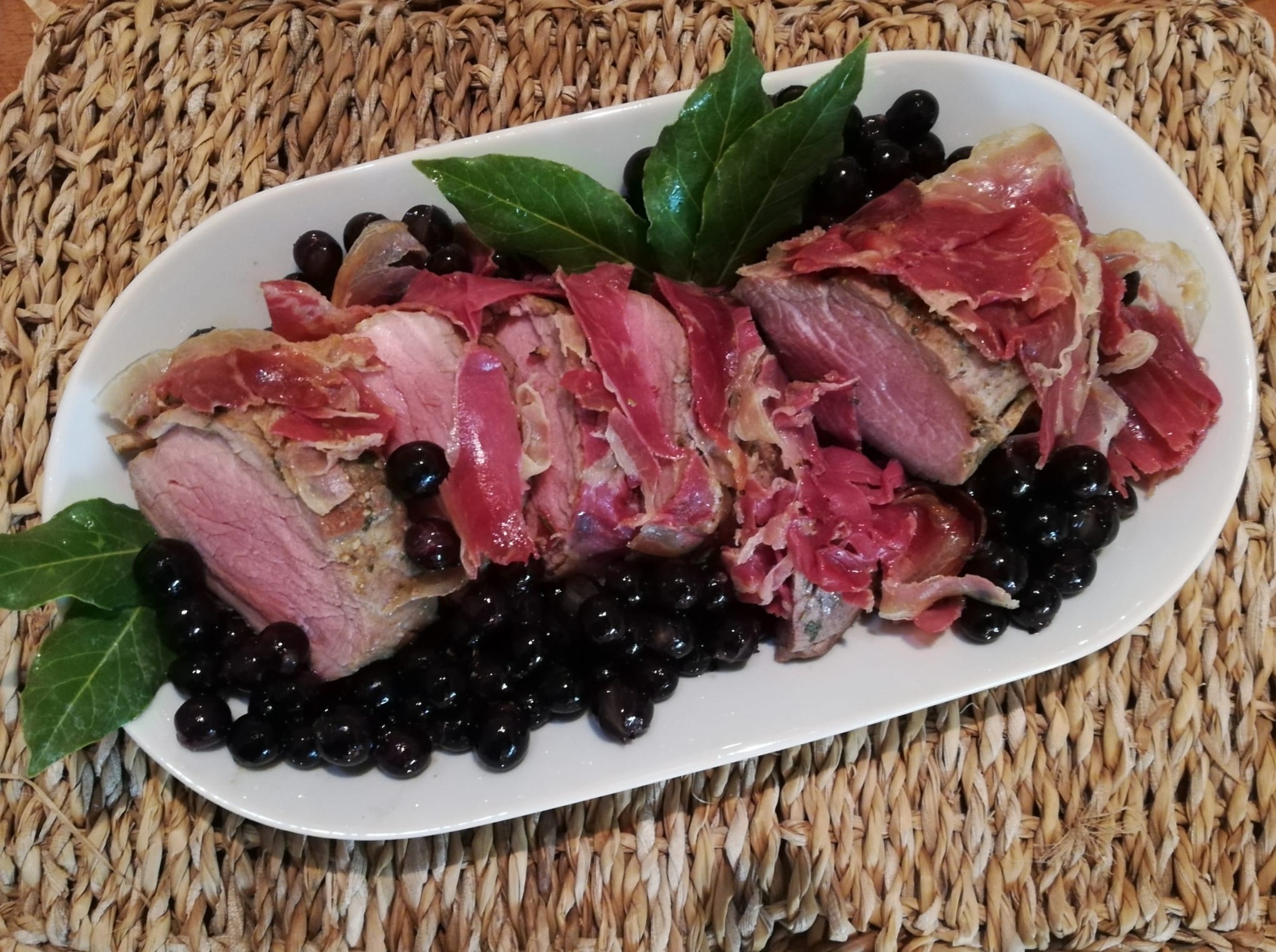 Filetto di maiale in crosta di pancetta e uva briaca