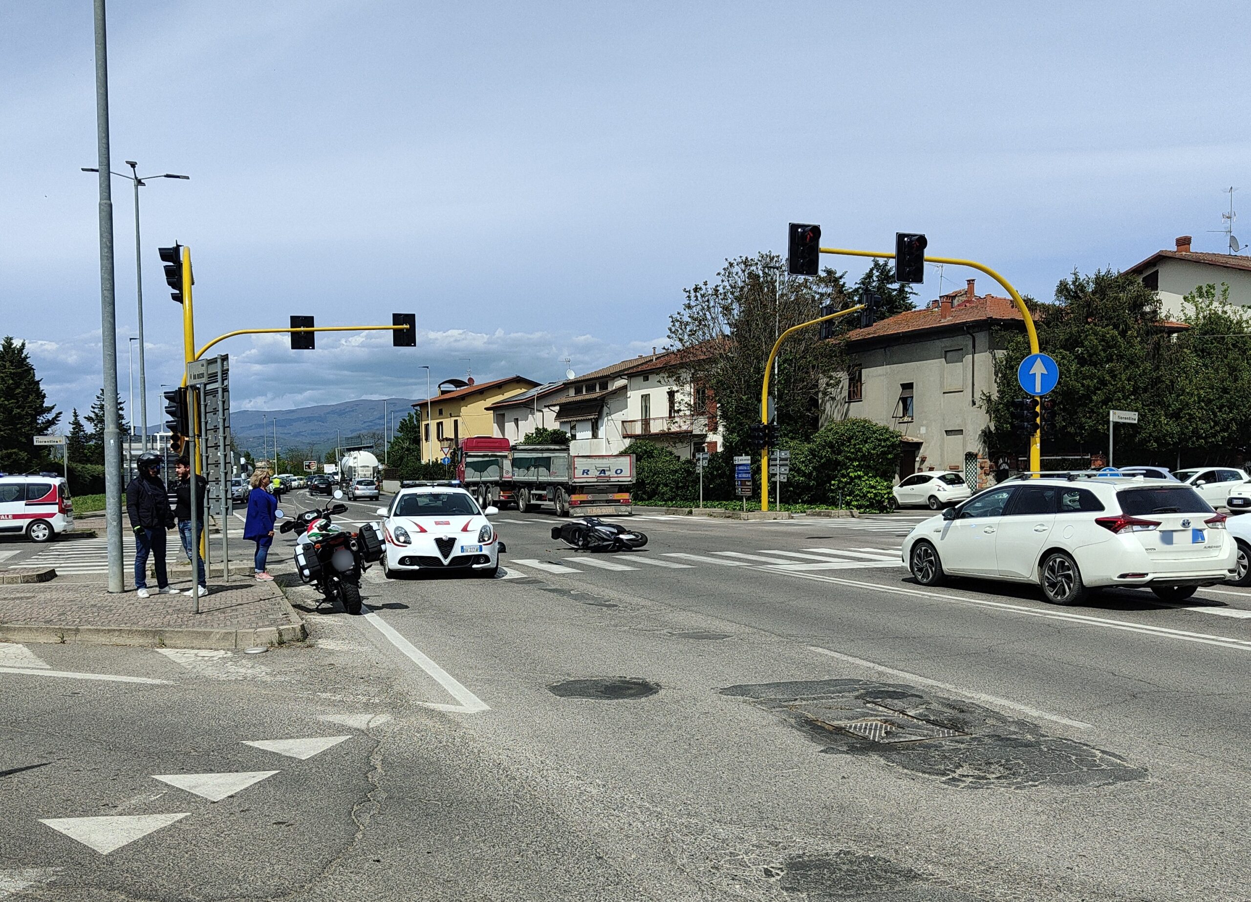 Vigili urbani in sirena urtano uno scooter al semaforo di via Fiorentina